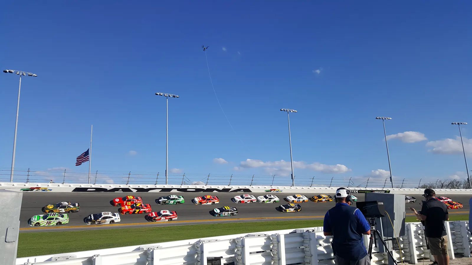 Kaze Aerial crew filming a NASCAR race from the infield, with the drone in the air